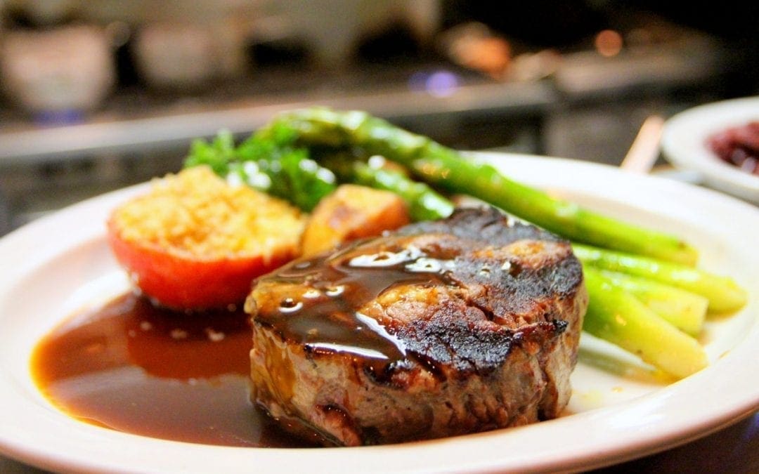 Steak with veggies on plate.